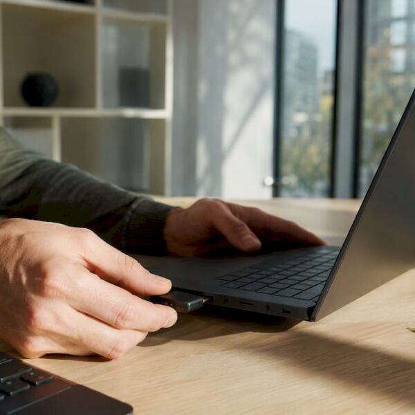 Eine Person steckt einen Sicherheitsschlüssel in ihren Laptop.