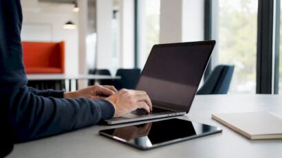 Jemand richtet WordPress auf einem Laptop ein und tippt dabei auf der Tastatur.