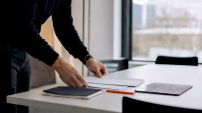 Hände, die Unterlagen für ein SEO-Briefing ordnen
