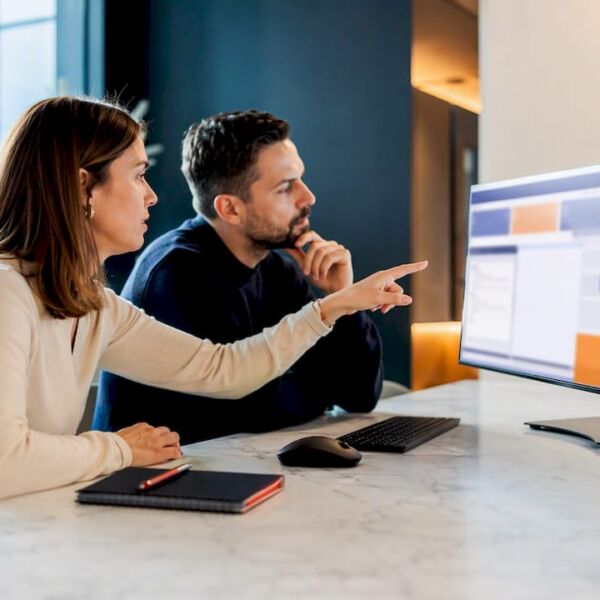 Team überprüft CRM-Datenmigration am Bildschirm